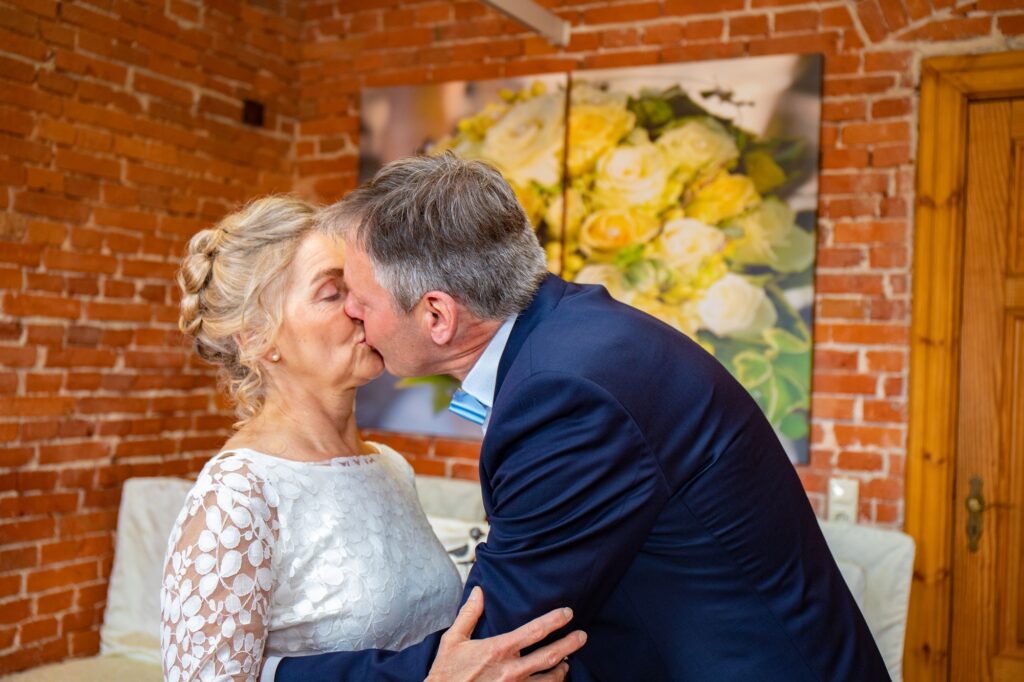 Kuss zwischen Braut und Bräutigam nach dem Ringtausch